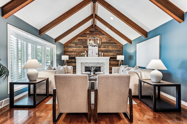 living room with wooden walls, a fireplace, dark hardwood / wood-style floors, and an inviting chandelier