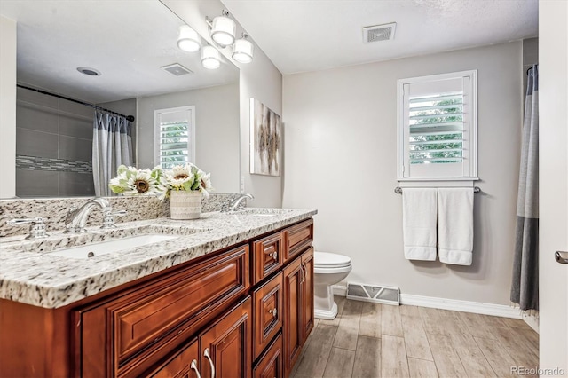 bathroom with walk in shower, vanity, and toilet