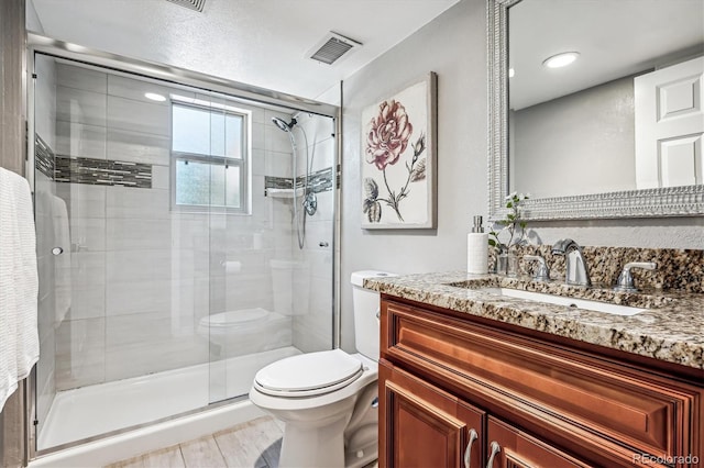 bathroom with vanity, toilet, a shower with door, and wood-type flooring