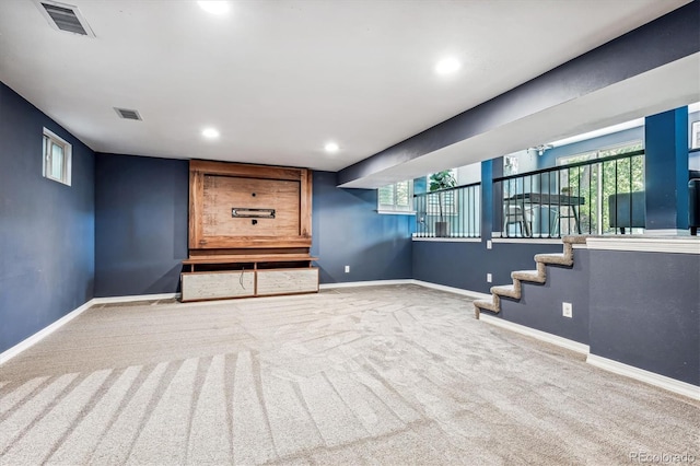 basement featuring a healthy amount of sunlight and light colored carpet