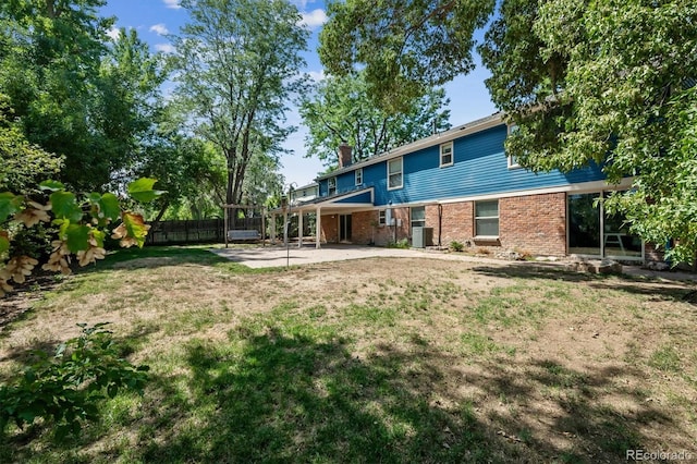 rear view of house featuring central air condition unit, a patio area, and a lawn