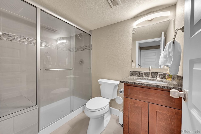 bathroom featuring vanity, a shower with shower door, a textured ceiling, and toilet