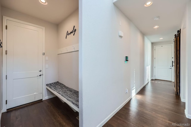 mudroom with dark wood-type flooring and a barn door