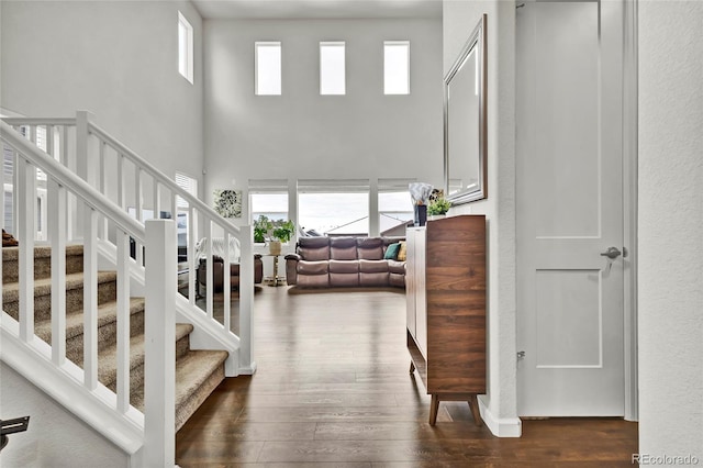 stairs featuring hardwood / wood-style flooring and a towering ceiling