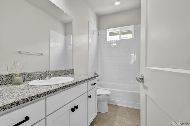 full bathroom featuring tiled shower / bath, vanity, and toilet