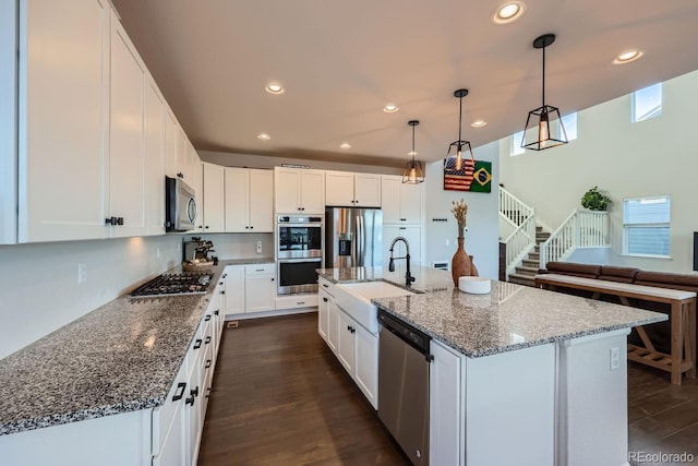 kitchen with stainless steel appliances, sink, and white cabinets