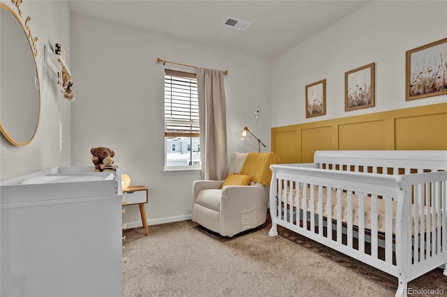 carpeted bedroom with a nursery area