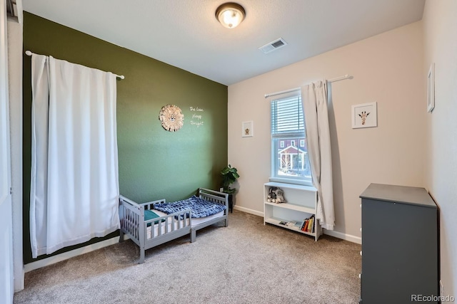 bedroom with a nursery area and carpet