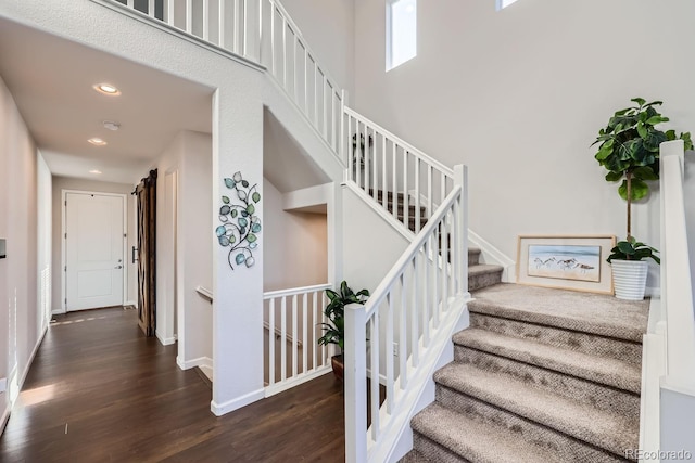 staircase featuring hardwood / wood-style floors and a high ceiling