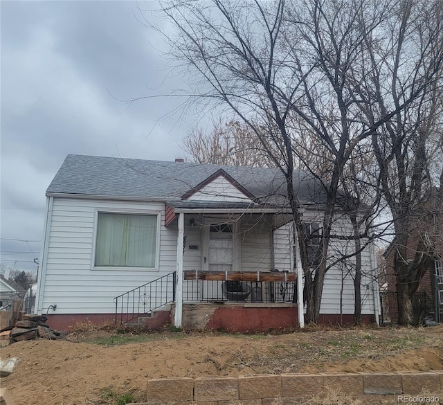 bungalow with a porch and roof with shingles