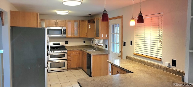 kitchen with sink, light tile patterned floors, stainless steel appliances, decorative light fixtures, and kitchen peninsula