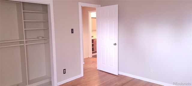 unfurnished bedroom with a closet and light wood-type flooring