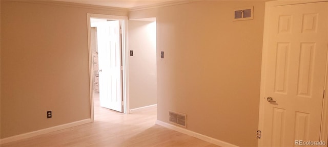 hall with ornamental molding and light hardwood / wood-style flooring