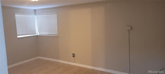 empty room with crown molding and wood-type flooring