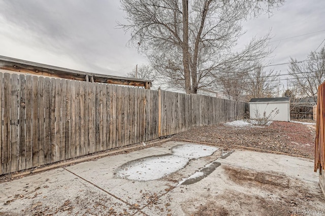 view of yard featuring a fenced backyard, an outdoor structure, a patio, and a shed