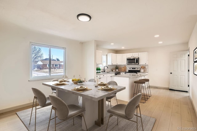 dining area featuring light wood-style floors, recessed lighting, and baseboards