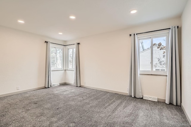 spare room featuring carpet floors, recessed lighting, visible vents, and baseboards