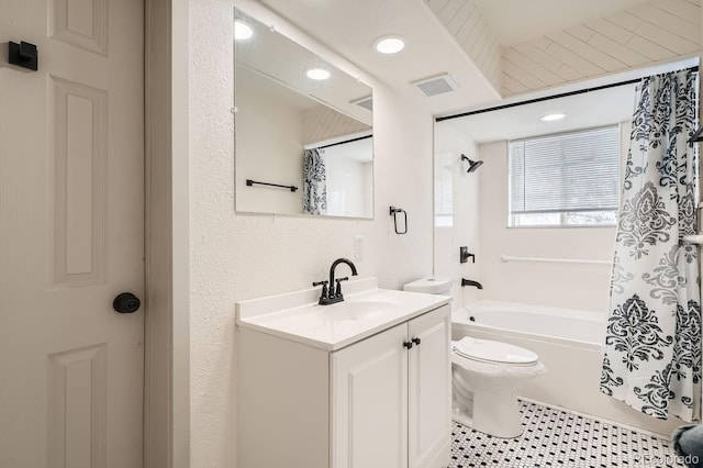 full bathroom with visible vents, toilet, shower / bath combo with shower curtain, vanity, and tile patterned floors