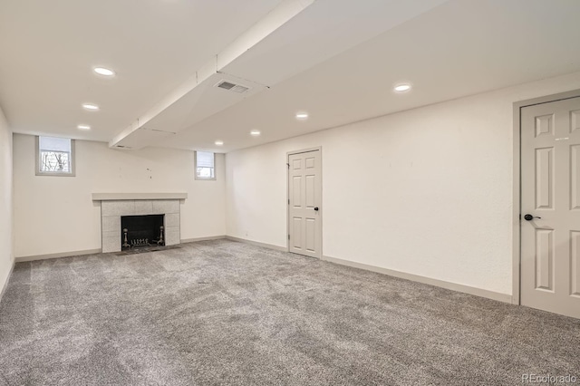 basement with carpet floors, plenty of natural light, visible vents, and baseboards