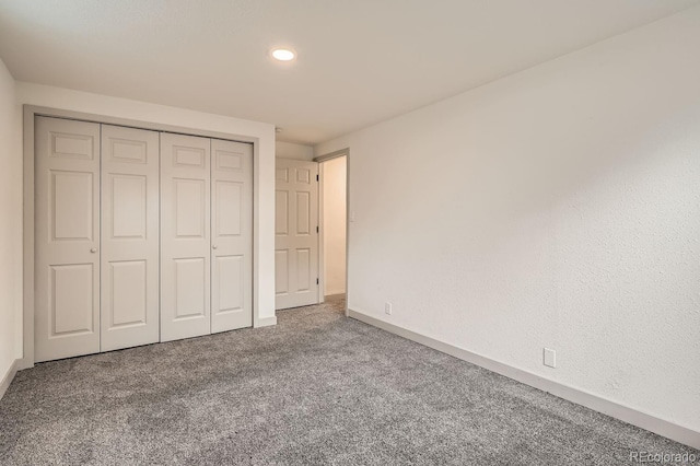 unfurnished bedroom featuring a closet, carpet flooring, and baseboards