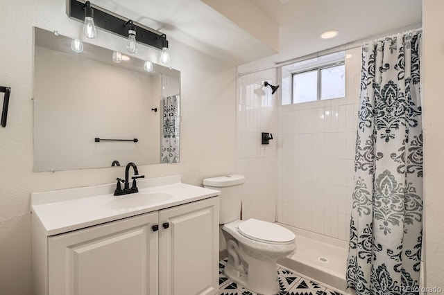 full bath featuring toilet, tiled shower, and vanity