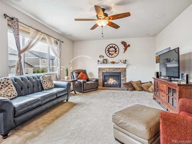 carpeted living room with ceiling fan and a fireplace