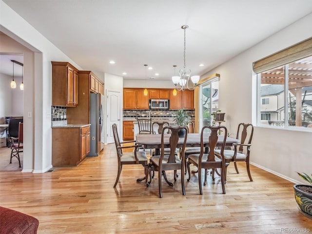 dining space featuring baseboards, recessed lighting, light wood-style flooring, and an inviting chandelier