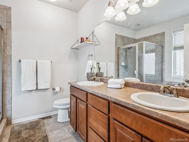 bathroom with double vanity, tile patterned floors, a sink, and a shower stall