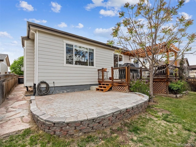 rear view of property with a patio area, a fenced backyard, a lawn, and a wooden deck