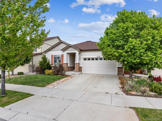6308 Walnut Grove Way, Erie, CO 80516 - view of front of house featuring concrete driveway, stone siding, a front lawn, and an attached garage