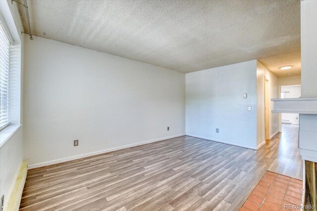 6007 Yarrow St Unit D, Arvada, CO 80004 - unfurnished living room with light wood-style floors and a textured ceiling