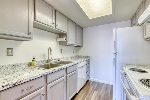 6007 Yarrow St Unit D, Arvada, CO 80004 - kitchen with white appliances, wood finished floors, exhaust hood, light countertops, and gray cabinets