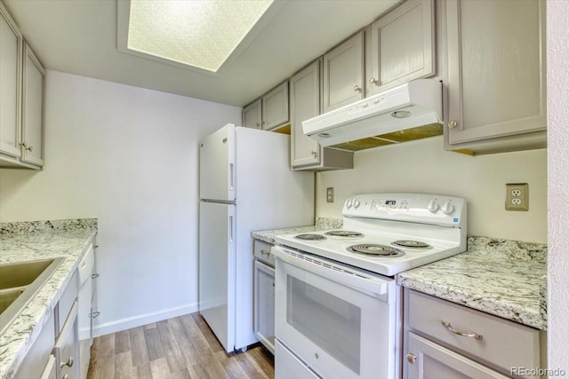 6007 Yarrow St Unit D, Arvada, CO 80004 - kitchen with white range with electric cooktop, under cabinet range hood, light wood-style floors, and gray cabinetry