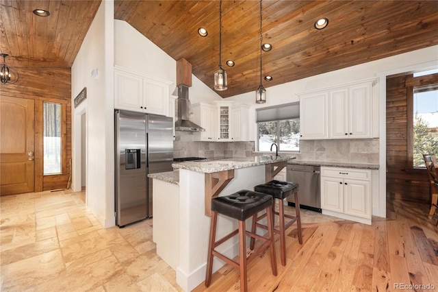 kitchen with stainless steel appliances, light stone countertops, a center island, and white cabinets