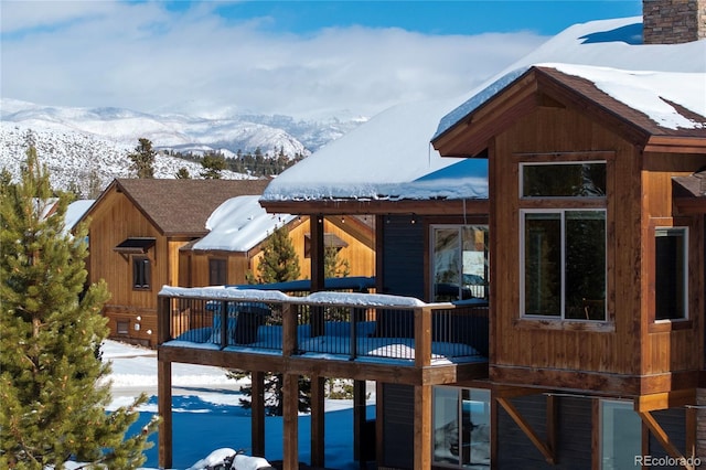 snow covered deck with a mountain view