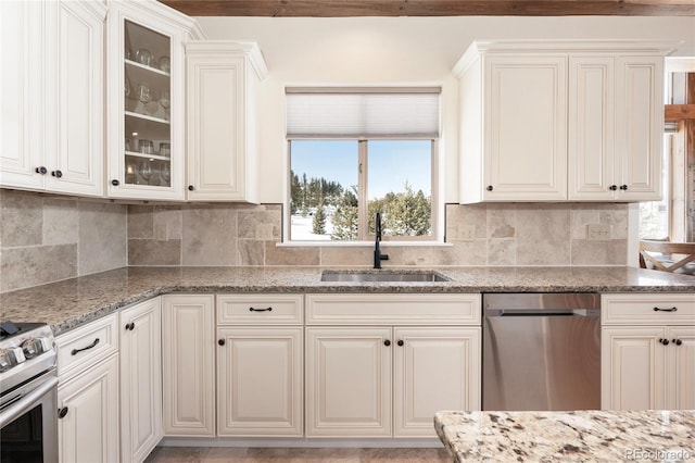 kitchen featuring sink, white cabinetry, tasteful backsplash, light stone counters, and stainless steel appliances