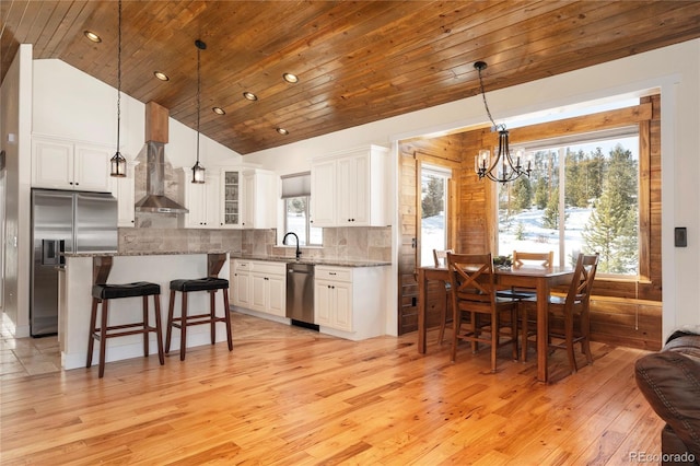 kitchen featuring light stone counters, decorative backsplash, stainless steel appliances, and white cabinets