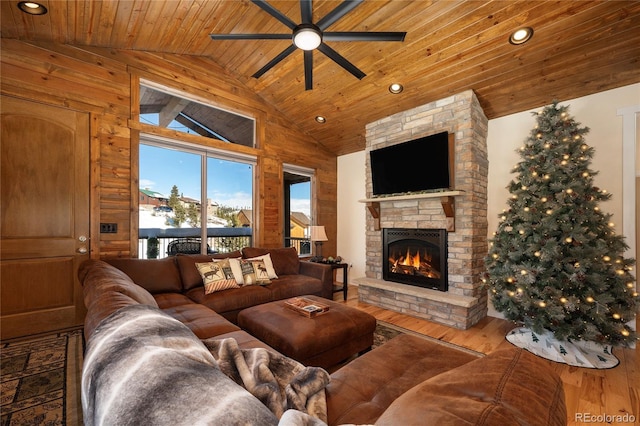 living room with wood-type flooring, a stone fireplace, vaulted ceiling, and wooden ceiling