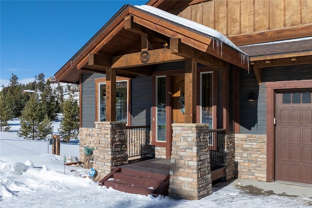 304 Gcr 424, Grand Lake, CO 80447 - snow covered property entrance featuring a porch, stone siding, and a garage