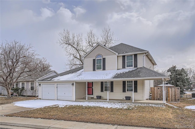 view of front of property featuring driveway, roof with shingles, an attached garage, fence, and a porch