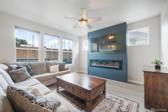 11524 Dewey St, Parker, CO 80138 - living area featuring ceiling fan, a large fireplace, baseboards, and wood finished floors