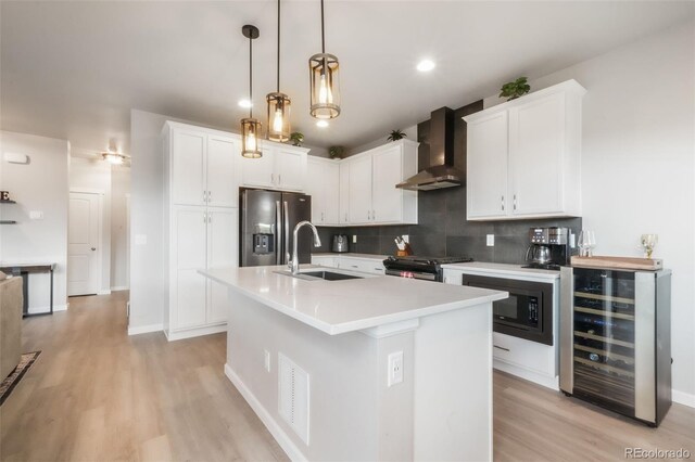 11524 Dewey St, Parker, CO 80138 - kitchen featuring beverage cooler, gas range, wall chimney range hood, stainless steel fridge, and a sink