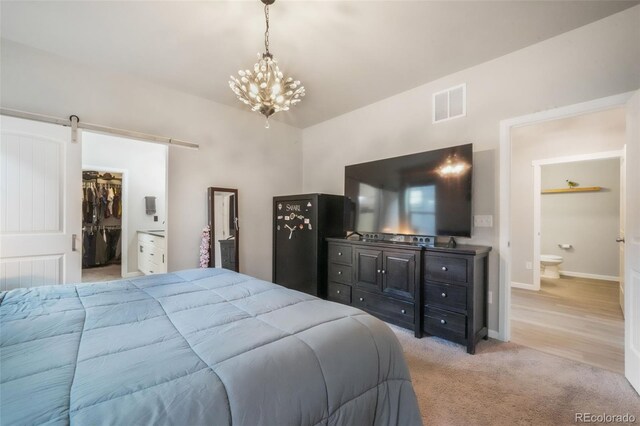 11524 Dewey St, Parker, CO 80138 - bedroom with a barn door, a walk in closet, light carpet, a chandelier, and visible vents