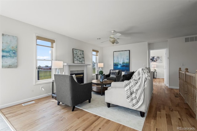 46531 Sundance Trl, Parker, CO 80138 - living area featuring light wood-type flooring, healthy amount of natural light, ceiling fan, and a fireplace