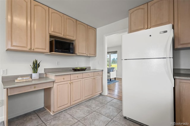 46531 Sundance Trl, Parker, CO 80138 - kitchen with freestanding refrigerator, light brown cabinetry, black microwave, and light countertops