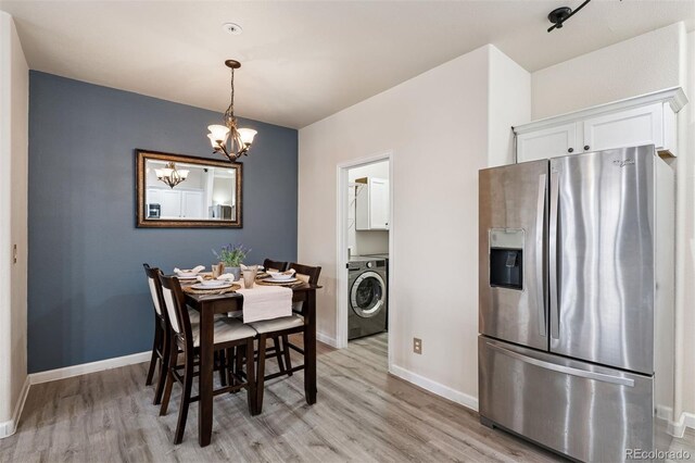 dining area with light wood-style floors, baseboards, washer / clothes dryer, and a notable chandelier