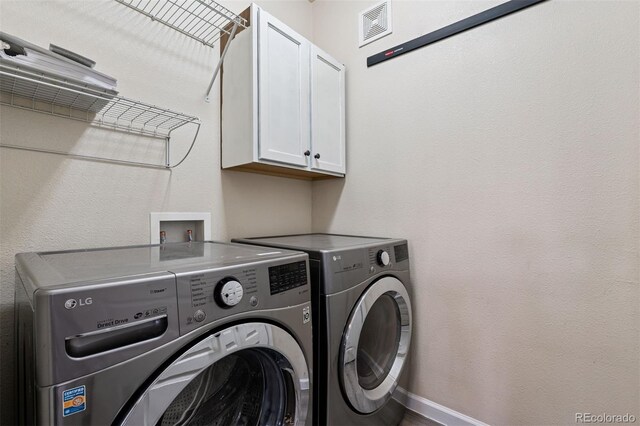 laundry room with cabinet space, baseboards, visible vents, and washing machine and dryer