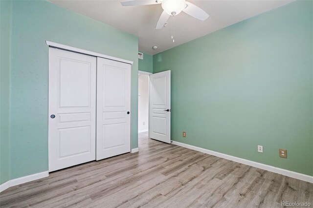 unfurnished bedroom featuring baseboards, a ceiling fan, a closet, and wood finished floors