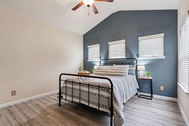 bedroom featuring baseboards, ceiling fan, wood finished floors, and vaulted ceiling