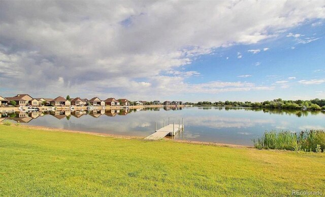 dock area with a lawn and a water view